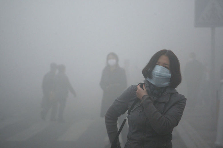 Girl walks through smog in Beijing, where small-particle pollution is 40 times higher than acceptable levels established by the WHO