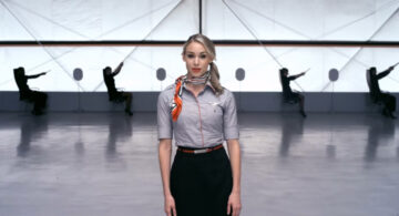 How Did Virgin Airlines Get 6 Million People To Watch A Flight Safety Video Without Stepping On A Plane? Virgin America flight attendant standing in a minimalist hangar with dancers demonstrating safety moves in the background.