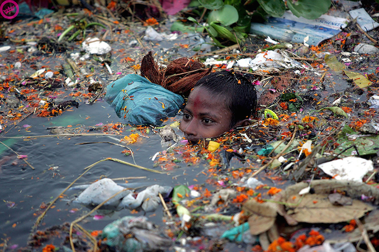 Boy swimming in polluted water in India