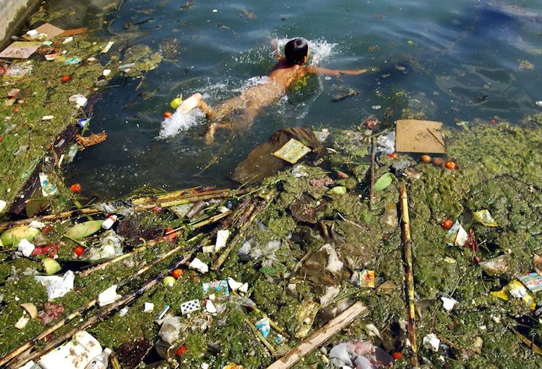 A child swims in a polluted reservoir in Pingba, China