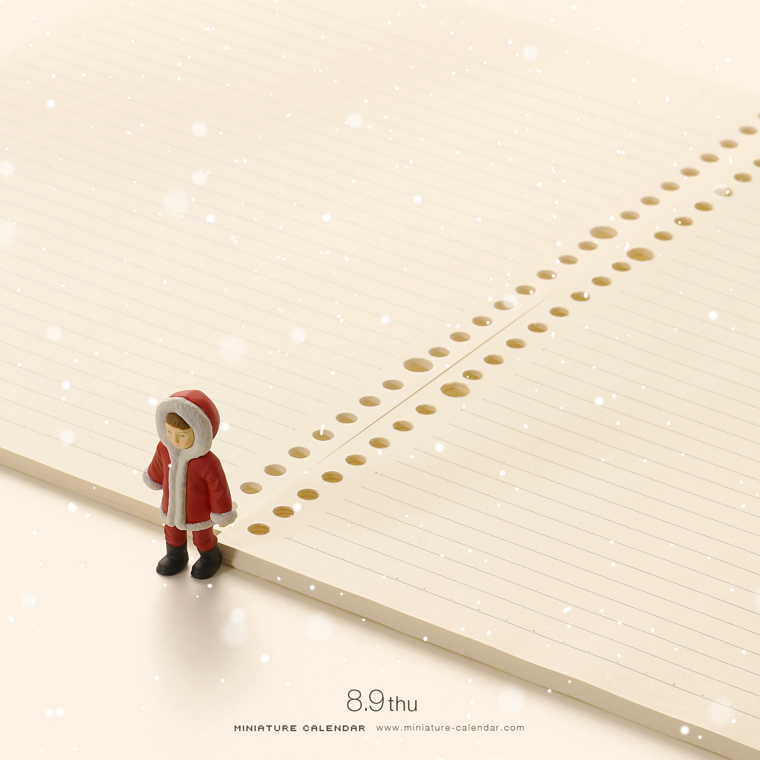Miniature girl in a red hooded Santa coat standing in the snow beside a notebook whose punched holes trail off like footprints