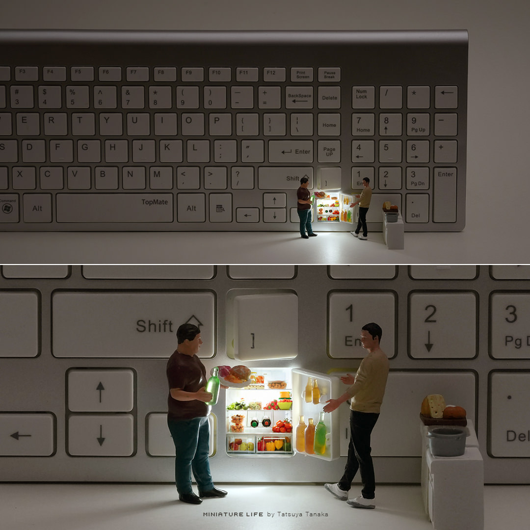Miniature people standing beside a glowing refrigerator hidden inside a computer keyboard
