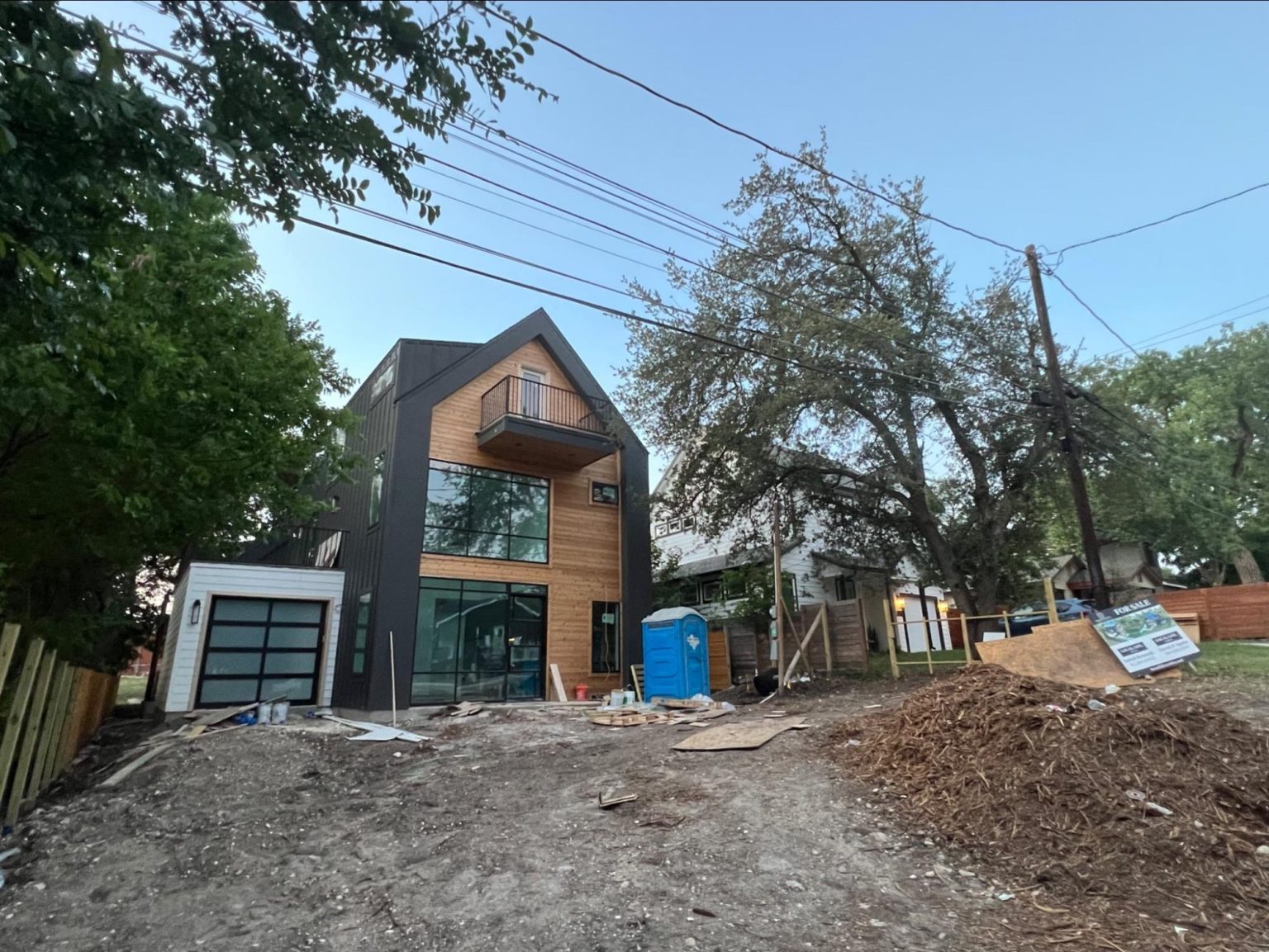 Modern house under construction with dark siding and wood accents — generic contemporary architecture