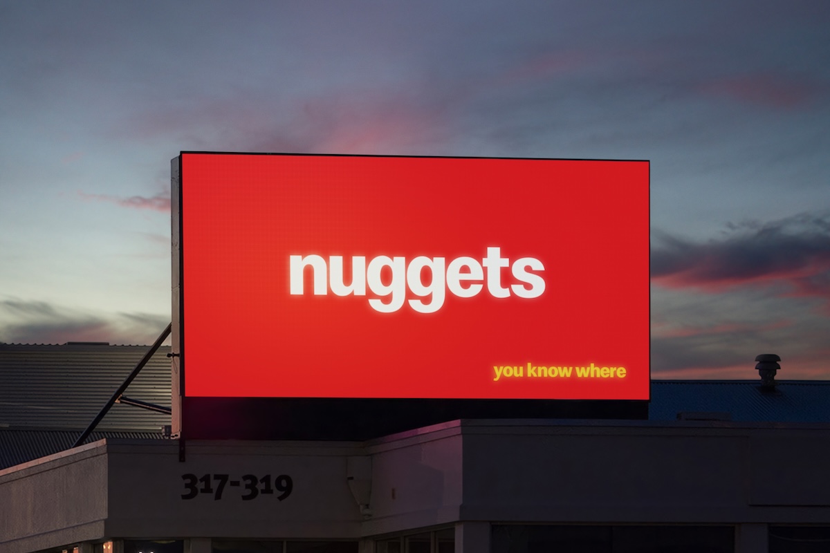 Minimal red outdoor billboard displaying the word “nuggets” and the phrase “you know where” in yellow, without a brand logo.