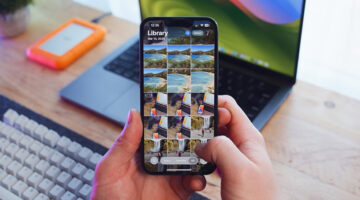 Person managing iPhone photo library to clean storage, with laptop and external drive on desk