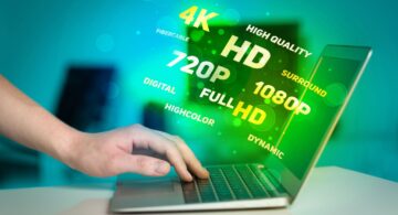 User interacting with a laptop surrounded by floating terms like 4K, HD, and Full HD representing visual performance and user experience quality