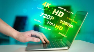 User interacting with a laptop surrounded by floating terms like 4K, HD, and Full HD representing visual performance and user experience quality