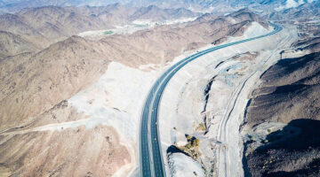 Aerial view of a modern Abu Dhabi highway running through desert mountains
