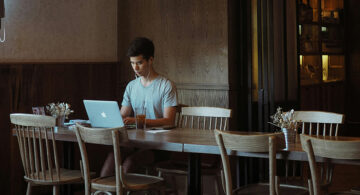 Designer working remotely on laptop in cafe workspace