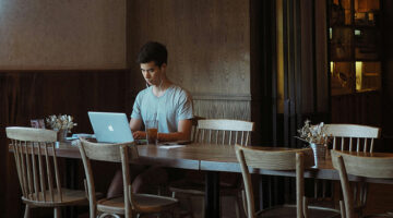 Designer working remotely on laptop in cafe workspace