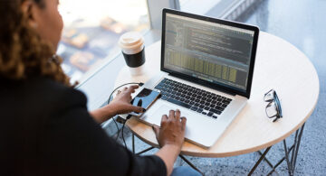 Software developer reviewing code on a laptop during software testing