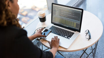 Software developer reviewing code on a laptop during software testing