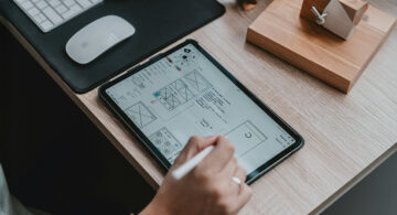 Designer creating UX wireframes on a tablet for a digital interface