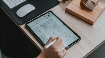 Designer creating UX wireframes on a tablet for a digital interface