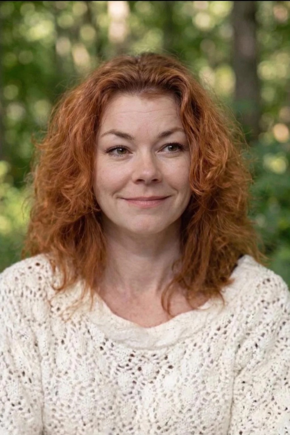 Restored smiling portrait of a woman with warm lighting and improved photo quality