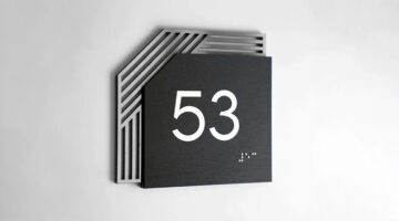 Modern property signage design with layered metal room number sign and raised numerals