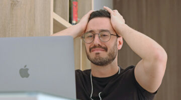 Frustrated content creator looking at laptop after getting low views on video thumbnails