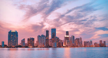 How Colorful Skies Make Instagram Photos More Eye-Catching City skyline with colorful pink and blue sunset sky reflected in water