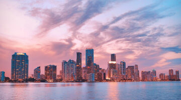 City skyline with colorful pink and blue sunset sky reflected in water