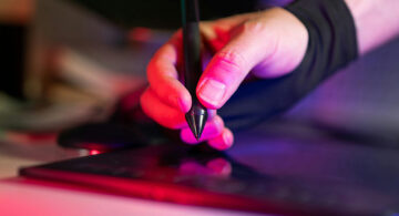 Freelance web designer using a graphics tablet while preparing a client website launch