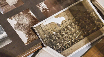 Damaged vintage photograph in an old album showing a torn military group portrait