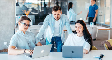 Professionals collaborating on laptops in a modern office, reflecting common career site design trends