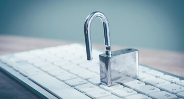 Open padlock on a computer keyboard representing business cybersecurity