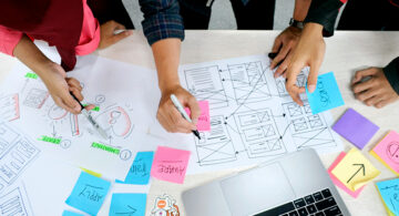 Design team mapping digital customer touchpoints with website wireframes
