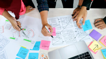 Design team mapping digital customer touchpoints with website wireframes