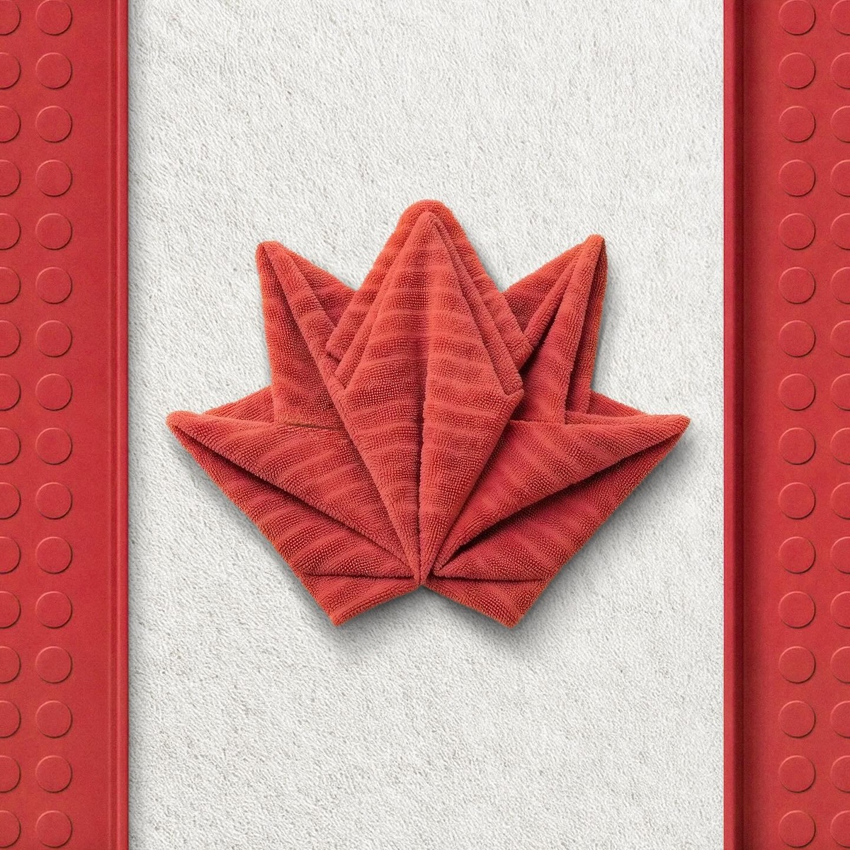 Canada flag recreated with red panels and a folded red towel shaped like a maple leaf using IKEA products