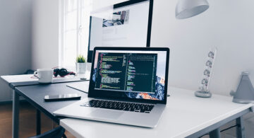 Should Designers Learn To Code In 2026? Here's What The Job Market Says Designer coding on a laptop at a modern workspace
