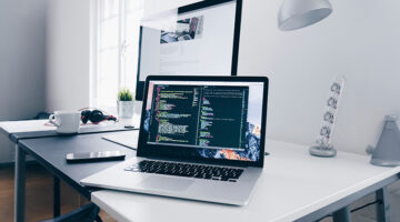 Designer coding on a laptop at a modern workspace