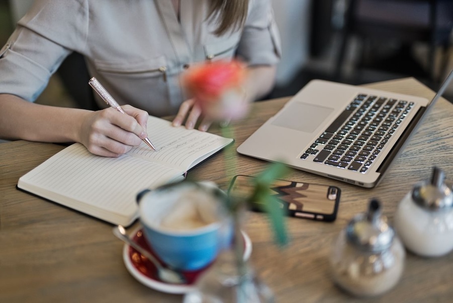 Creative professional reviewing content for errors beside a laptop