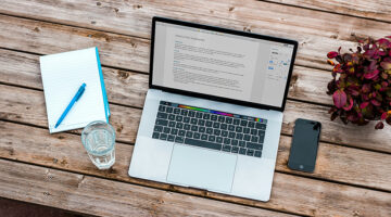 Laptop displaying a business document while comparing LMS pricing plans
