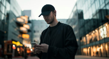 Professional using a smartphone outdoors, illustrating the rise of mobile productivity software and digital workflows beyond the desk.