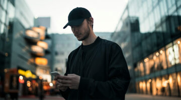 Professional using a smartphone outdoors, illustrating the rise of mobile productivity software and digital workflows beyond the desk.